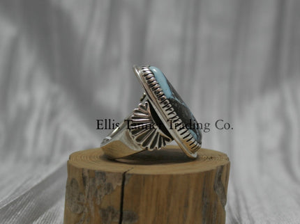 Tommy Jackson Black Diamond Turquoise side view, stamped overlay on top of band, On top of wooden display 