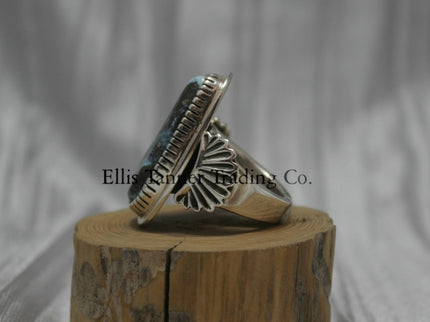 Tommy Jackson Black Diamond Turquoise side view, stamped overlay on top of band, On top of wooden display 