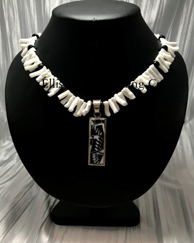White coral choker with black onyx beads, in the center is a rectangular silver inlayed onyx and white coral pendant. 