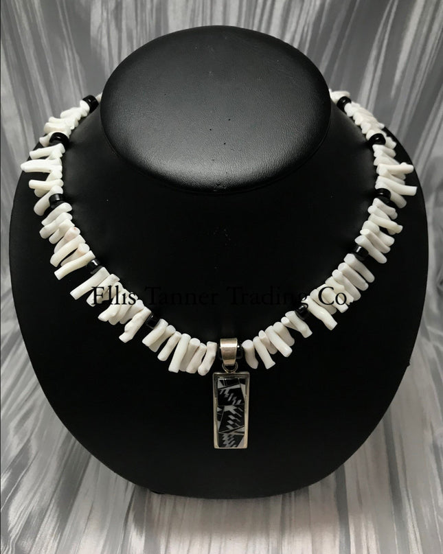 White coral choker with black onyx beads, in the center is a rectangular silver inlayed onyx and white coral pendant. 