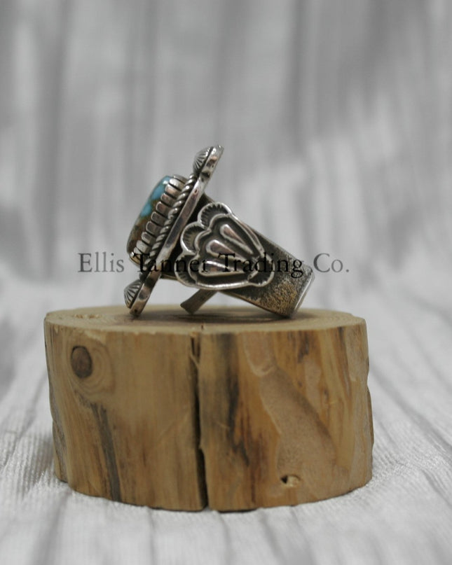 Tommy Jackson Square Royston Turquoise, silver band with silver stamped overlay, on top of a wooden display, side view 